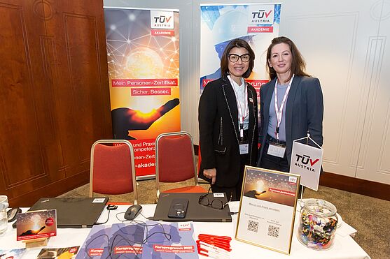 Mitarbeiterinnen der TÜV AUSTRIA Akademie, beantworteten gerne Fragen rund um das Thema Zertifizierung.<br /> Zwei lächelnde Damen hinter einem Ausstellerstand.