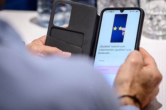 Mann beantwortet Frage auf einem Smartphone.