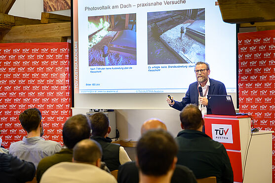 Dipl.-HTL-Ing. Kurt Danzinger, MSc (MA 39, Prüf-, Inspektions- und Zertifizierungsstelle der Stadt Wien) berichtete von aktuellen Erkenntnissen aus Brandversuchen zu gebäudeintegrierten Photovoltaik-Anlagen (BiPV).<br /> Mann hält Präsentation