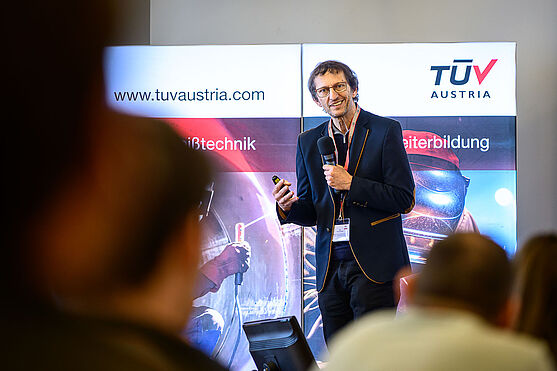 Ernst Pichler (ehem. Ögussa Österreichische Gold- und Silber-Scheideanstalt Ges.m.b.H.) widmete sich dem Thema Hartlöten: Lötfehler und deren Ursache.<br /> Ein Mann mit kurzen, dunklen Haaren und einem dunklen Anzug hält einen Vortrag auf einer Bühne.