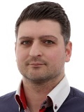 Christoph Krupitza, ein Mann mit schwarzen, kurzen Haaren, blickt freundlich in die Kamera.
