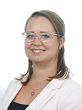 Pia Bräuhofer, eine Frau mit Brille, trägt einen pinken Blazer und lächelt freundlich in die Kamera.