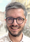 Freundlich lächelnder Mann mit Vollbart und Brille